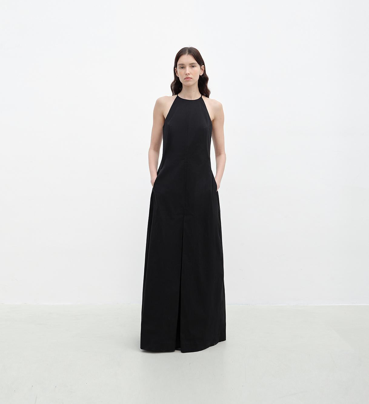Woman wearing a black halter neck dress on a white background