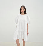 Woman wearing a white dress against a plain background