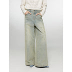 Person wearing light blue jeans and a white sweater on a white background