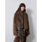 Woman wearing a brown fur coat with a plain background