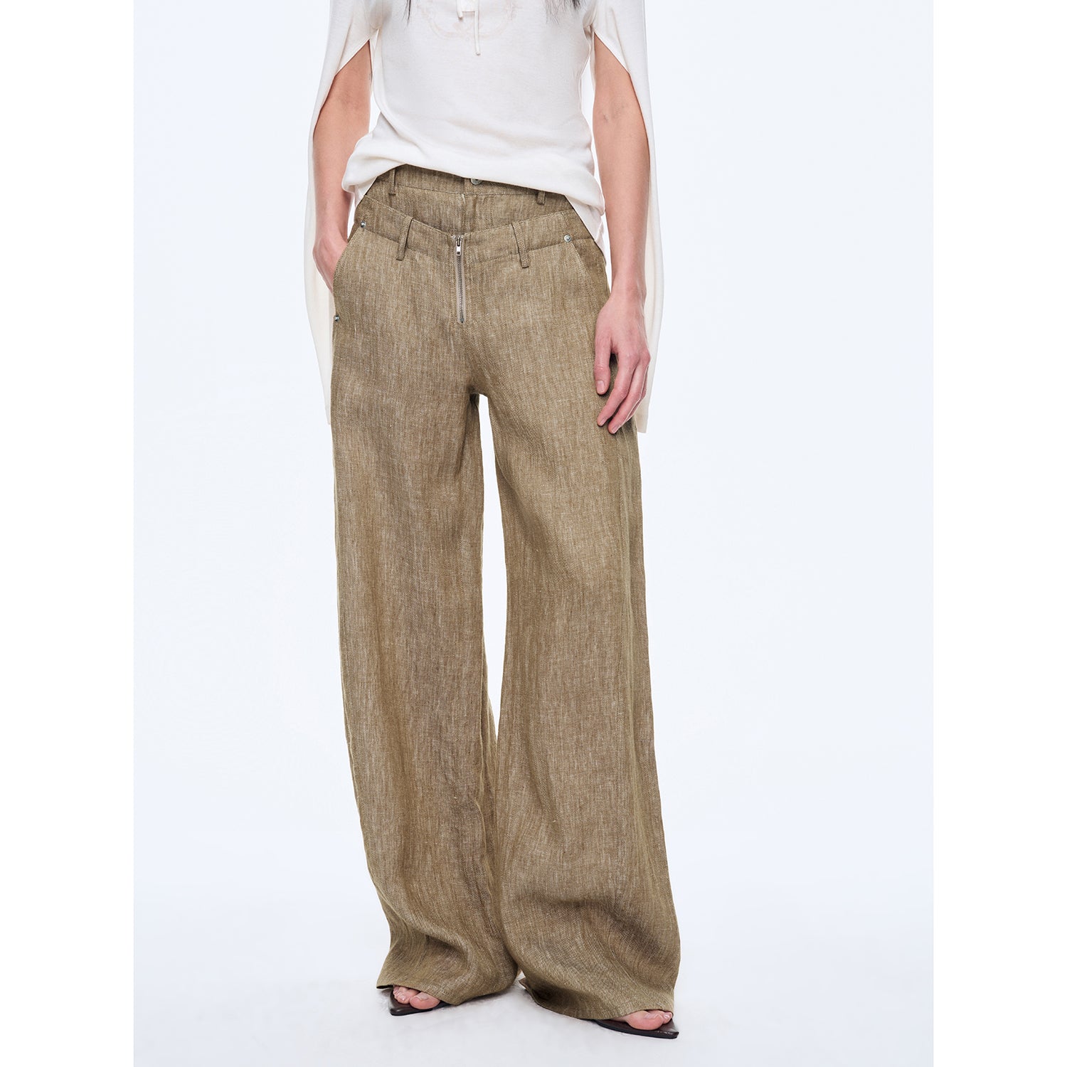 Person wearing beige wide-leg pants on a white background