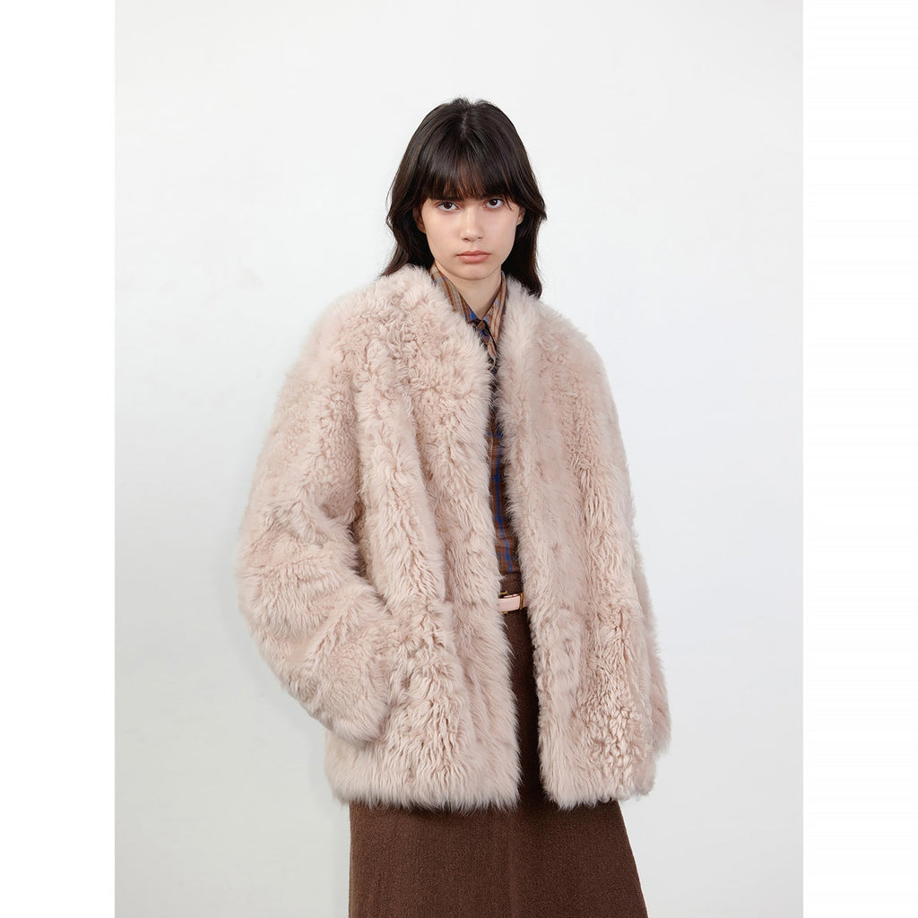 Person wearing a fluffy beige coat on a white background