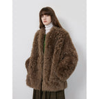 Person wearing a brown fur coat against a white background
