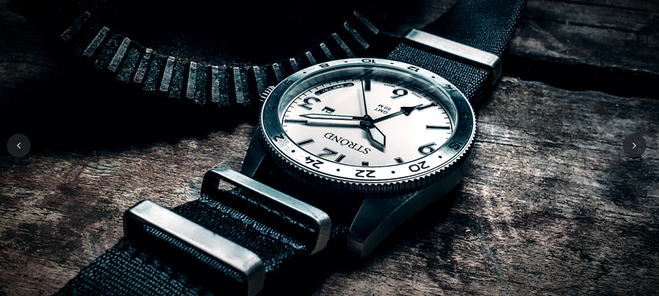 Wristwatch with a black strap on a wooden surface