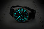Watch with a glowing face on a dark background