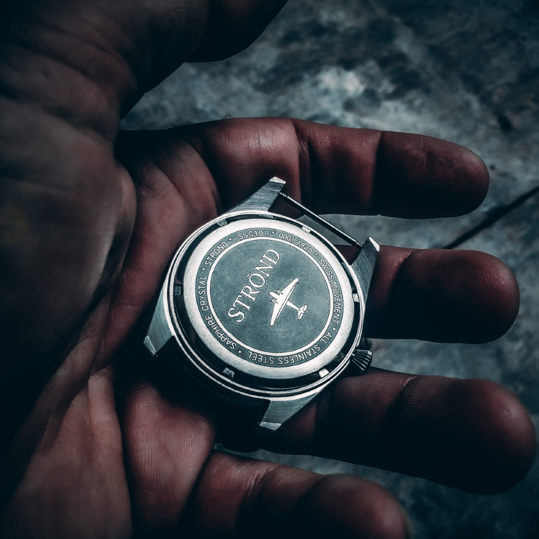 Hand holding a Strnd watch with a blurred background