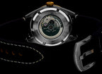 Watch with open face revealing mechanical components on a black background