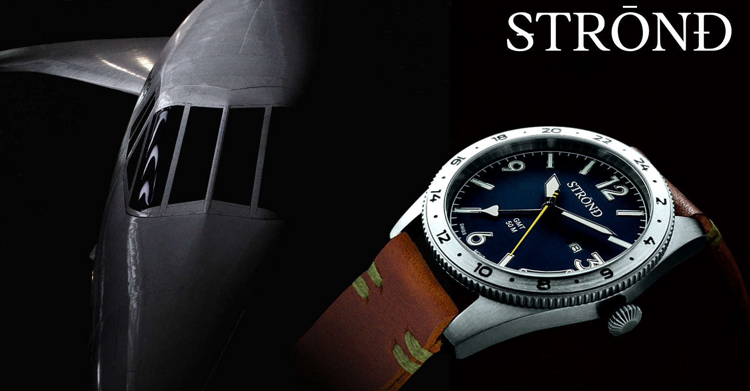 Watch with a dark face and brown strap on a black background, featuring the brand 'STRØND'.