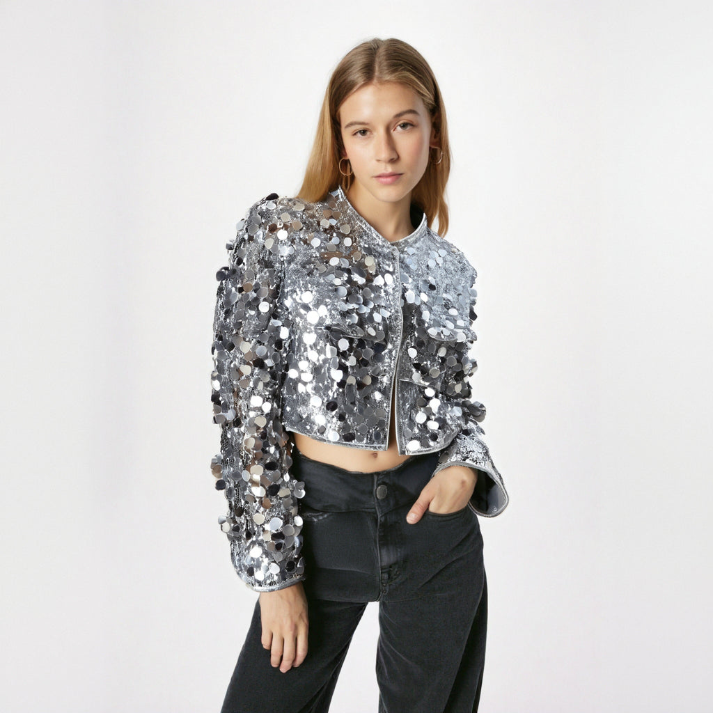 Person wearing a silver sequin jacket on a white background