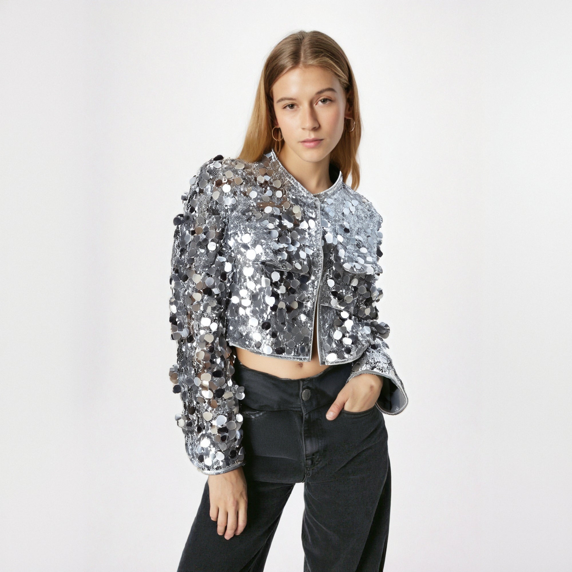 Person wearing a silver sequin jacket on a white background