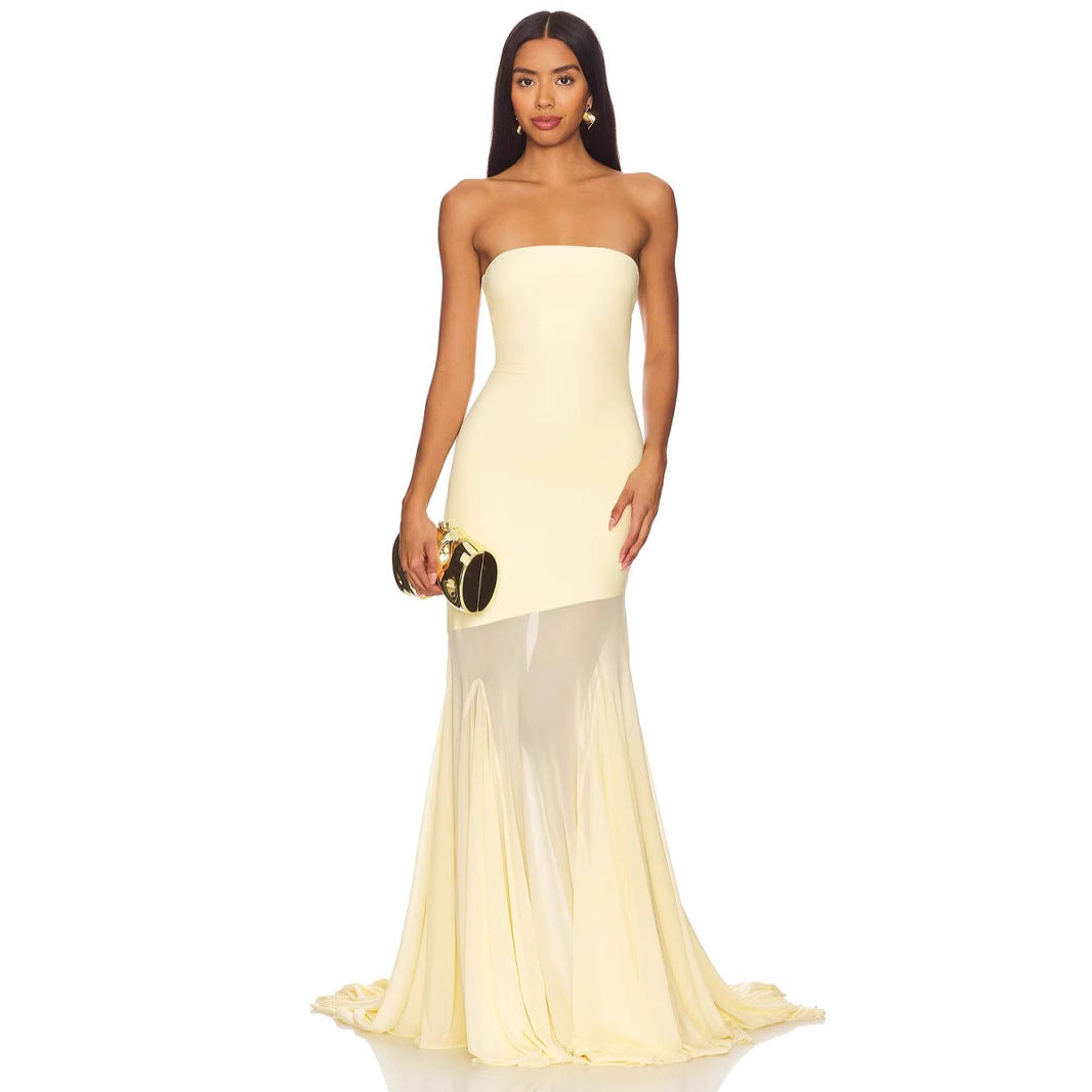 Woman wearing a strapless yellow evening gown on a white background