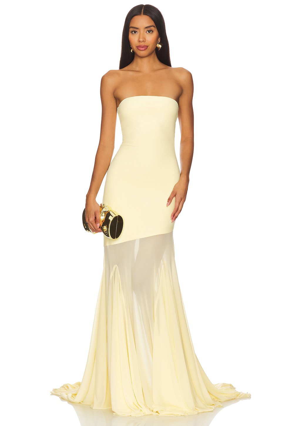 Woman wearing a strapless yellow evening gown with a sheer overlay on a white background