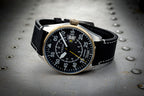 Wristwatch with black strap and detailed face on a metallic surface