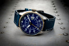 Wristwatch with blue strap and blue dial on a metallic surface