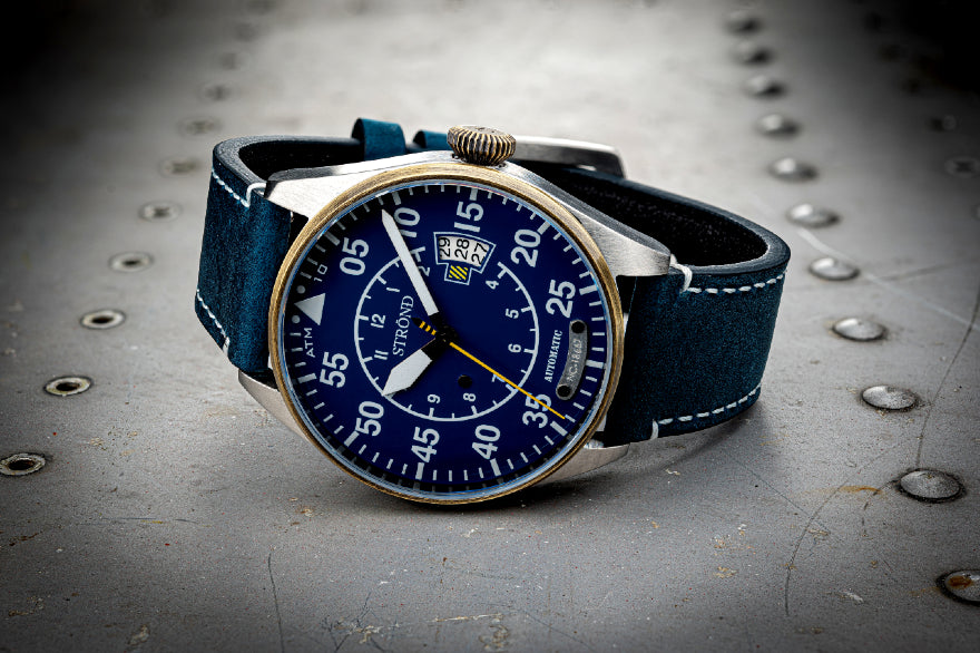 Wristwatch with blue strap and blue dial on a metallic surface