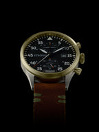 Wristwatch with a brown leather strap and gold case on a black background