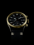 Wristwatch with black dial and gold casing on a black background