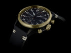 Wristwatch with black strap and gold case on a black background