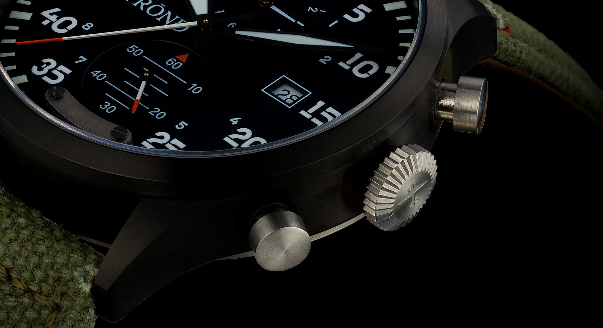 Close-up of a black wristwatch with detailed design on a dark background
