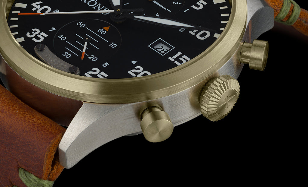 Close-up of a watch with a gold bezel and brown leather strap on a black background