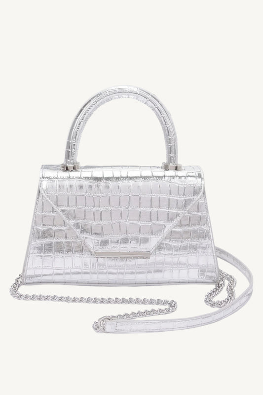 "Crocodile-embossed metallic leather top handle bag – luxurious and chic statement accessory with mixed metal accents."