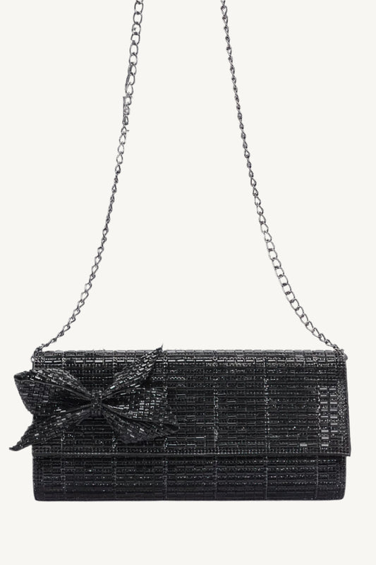 Structured evening clutch covered in rhinestones with a rhinestone bow accent, metal frame, and clasp closure – elegant, compact, and perfect for special occasions.