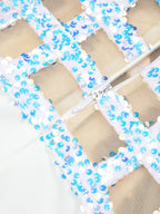 Close-up of a decorative mesh panel with blue and white beads on a beige background