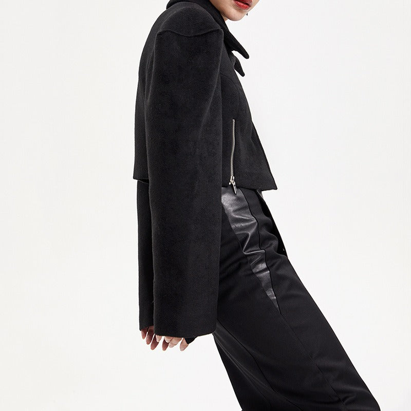 Person wearing a black coat and pants on a white background