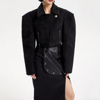 Black coat with leather accents worn by a model on a white background