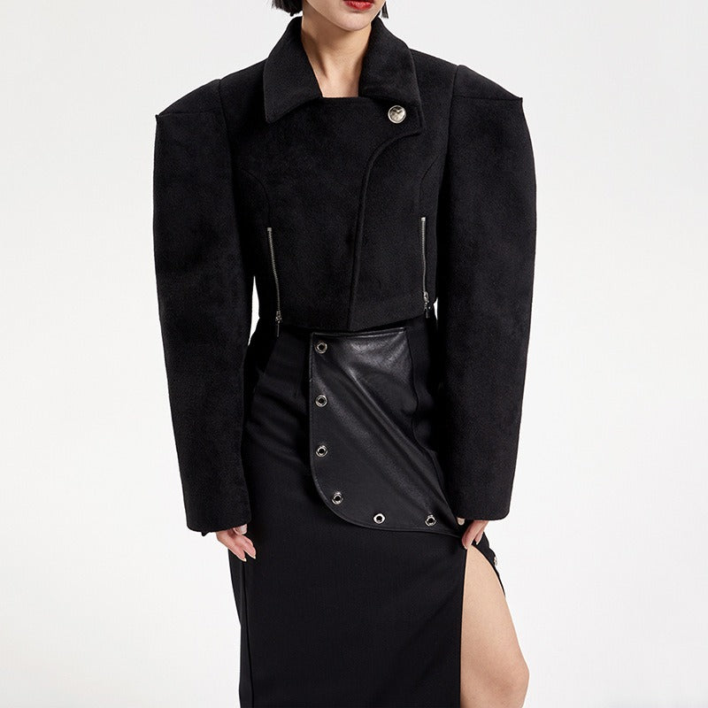 Black coat with leather accents worn by a model on a white background