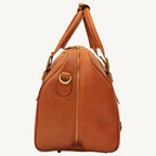 "Full-grain calfskin leather travel bag with synthetic lining, interior zip pocket, and padded adjustable strap – stylish and durable for travel"