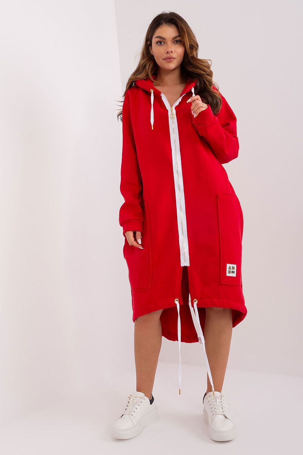 Person wearing a red hoodie dress with white accents on a white background