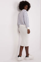 Person wearing a striped sweater and white pants against a plain background