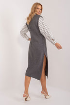 Woman wearing a gray dress over a striped shirt on a white background