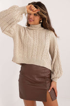 Woman wearing a beige cable knit sweater and brown leather skirt on a white background