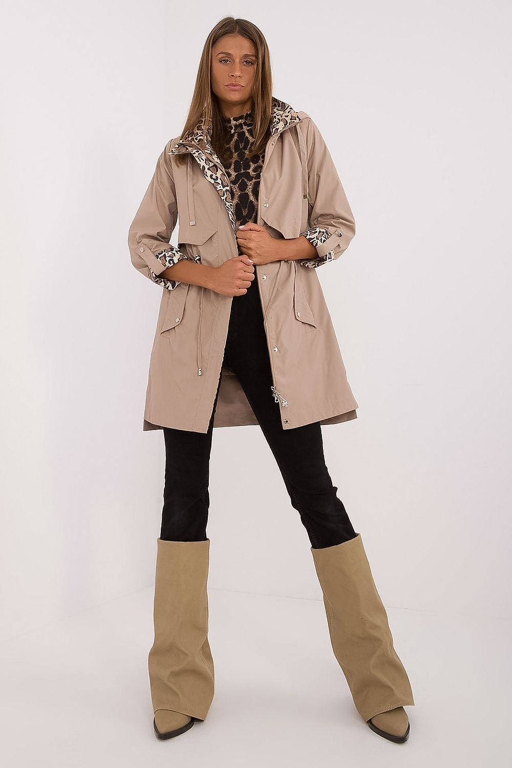 Woman wearing a beige trench coat with leopard print accents on a white background