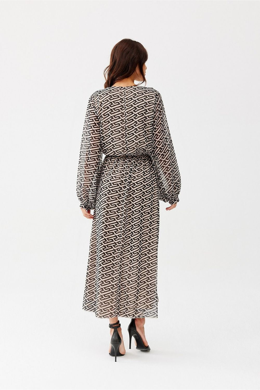 Woman wearing a patterned dress on a white background