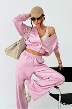 Woman in pink outfit with beige cap and bag on white background