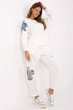 Woman wearing a white outfit with blue patterns on a white background