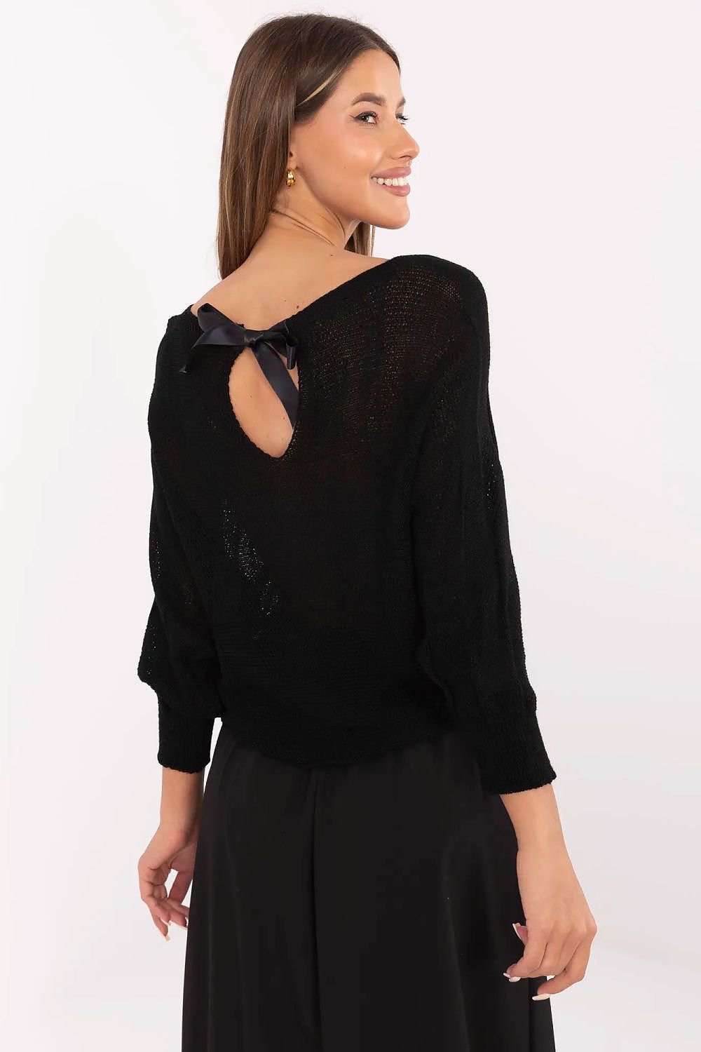 Woman wearing a black blouse with a cut-out design on a white background