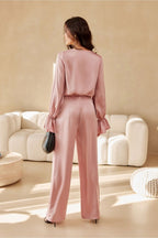 Woman in a pink outfit standing in a modern living room.