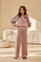 Woman in a pink outfit standing in a modern living room.
