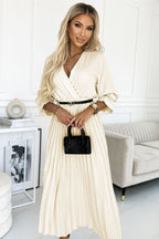 Woman in a white dress holding a black handbag in a modern living room.