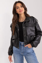Woman wearing a black leather jacket and blue jeans on a white background