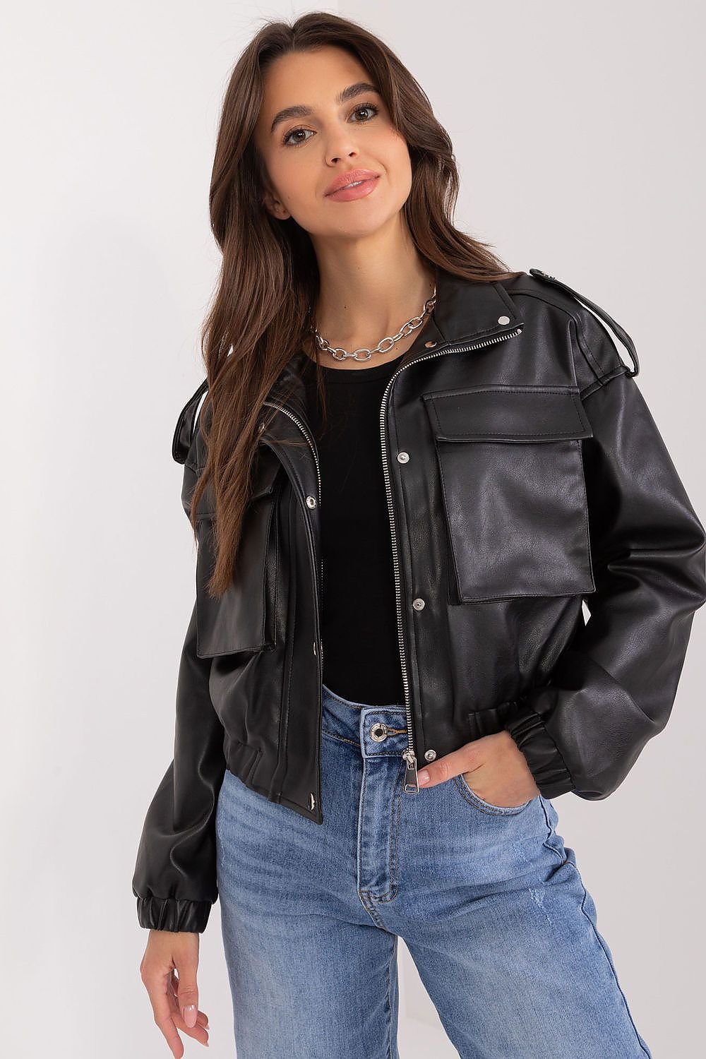 Woman wearing a black leather jacket and blue jeans on a white background