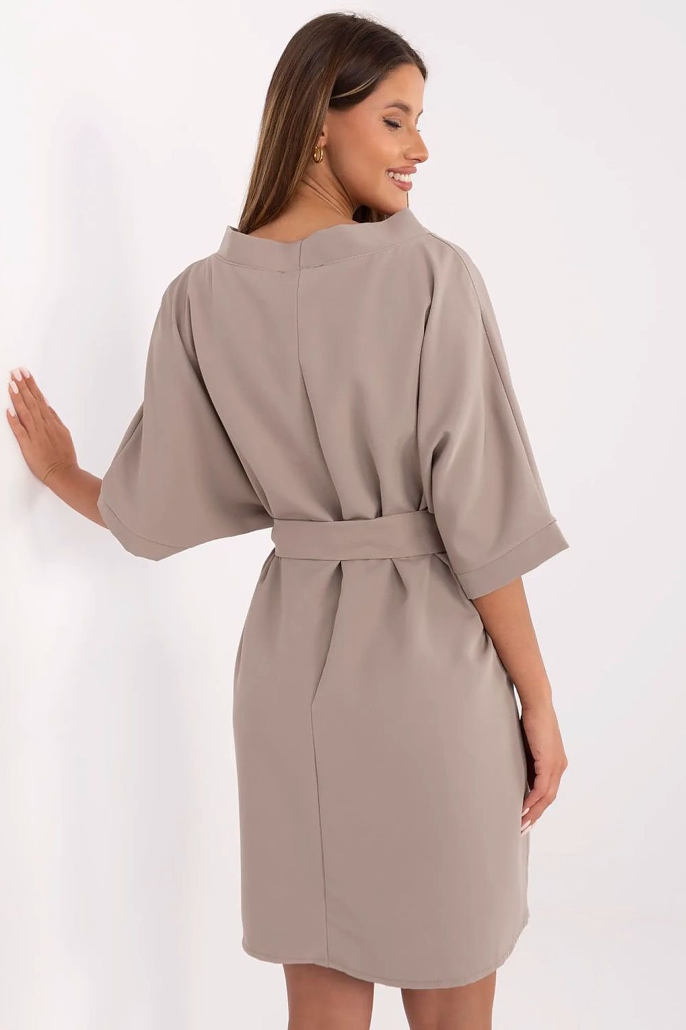 Woman wearing a beige robe against a white background