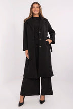 Woman wearing a black coat and pants on a white background