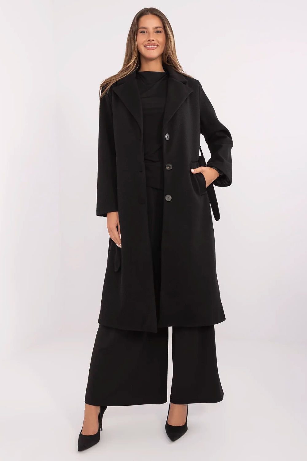 Woman wearing a black coat and pants on a white background