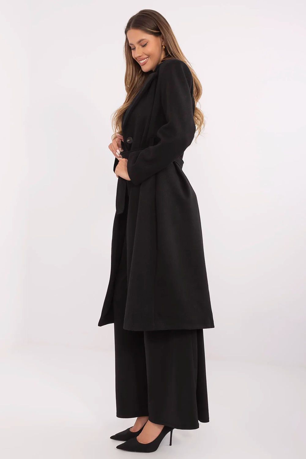 Woman wearing a black coat and pants on a white background