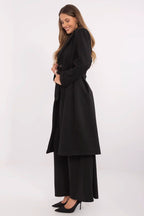 Woman wearing a black coat and pants on a white background